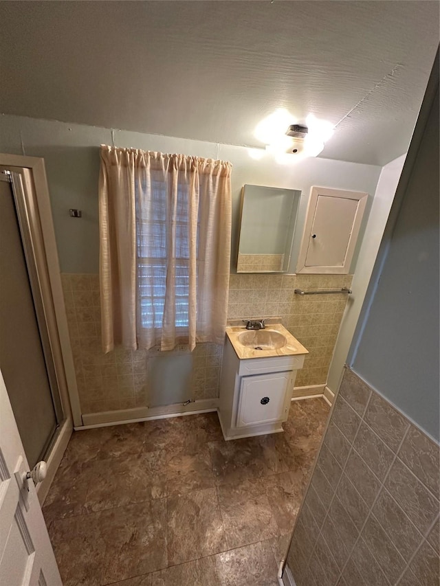 bathroom featuring vanity and tile walls