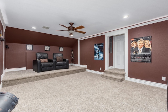 carpeted cinema room with ceiling fan and ornamental molding