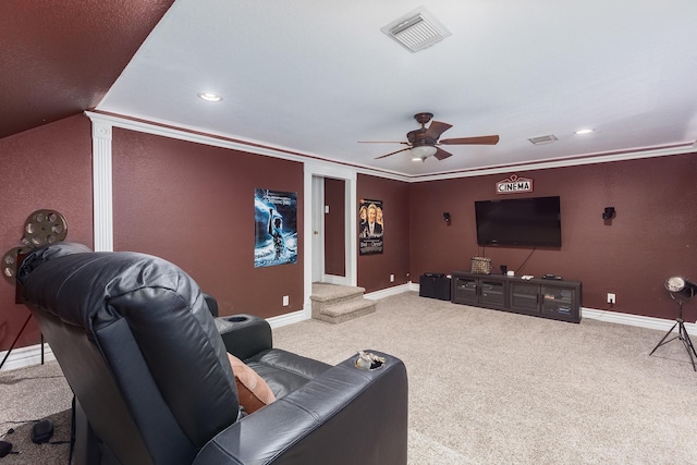 home theater featuring ceiling fan, light colored carpet, and ornamental molding