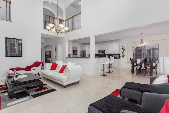 living room featuring a towering ceiling and a notable chandelier