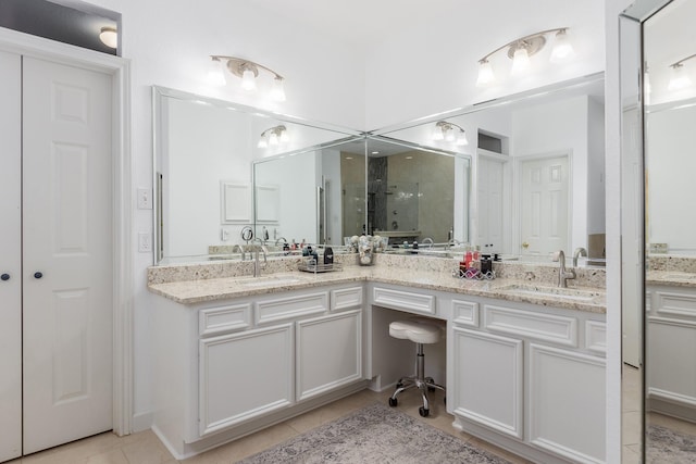 bathroom featuring tile patterned flooring, vanity, and walk in shower