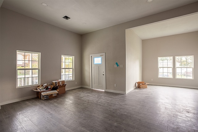 entryway with dark hardwood / wood-style flooring and a high ceiling