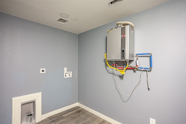 washroom with electric dryer hookup, wood-type flooring, a textured ceiling, and water heater