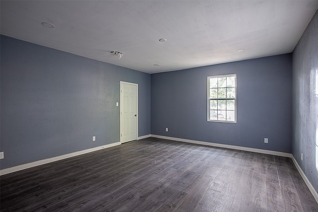 unfurnished room with dark wood-type flooring