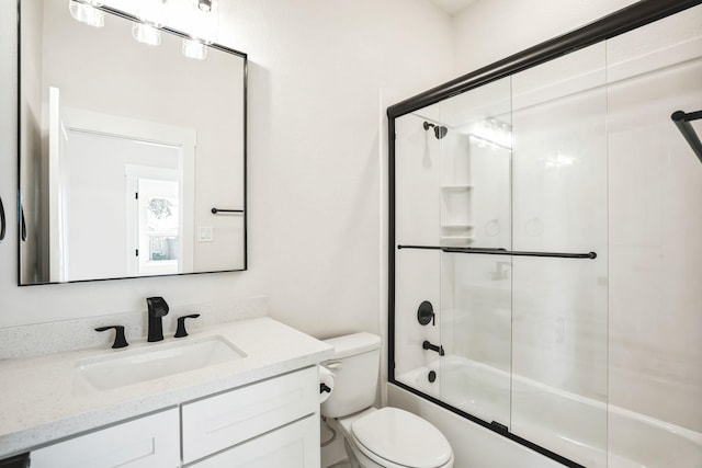 full bathroom with vanity, toilet, and bath / shower combo with glass door