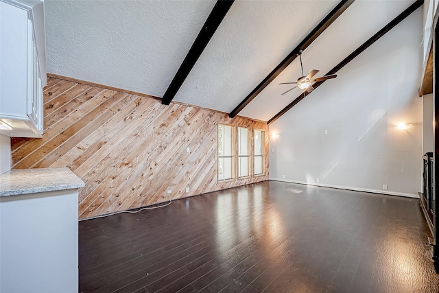 unfurnished living room with vaulted ceiling with beams, hardwood / wood-style flooring, and ceiling fan