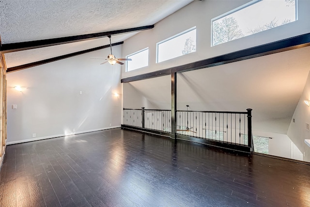 interior space with beamed ceiling, ceiling fan, dark hardwood / wood-style flooring, and a textured ceiling