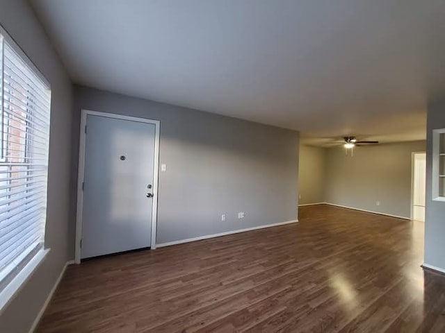 empty room featuring ceiling fan and dark wood-type flooring