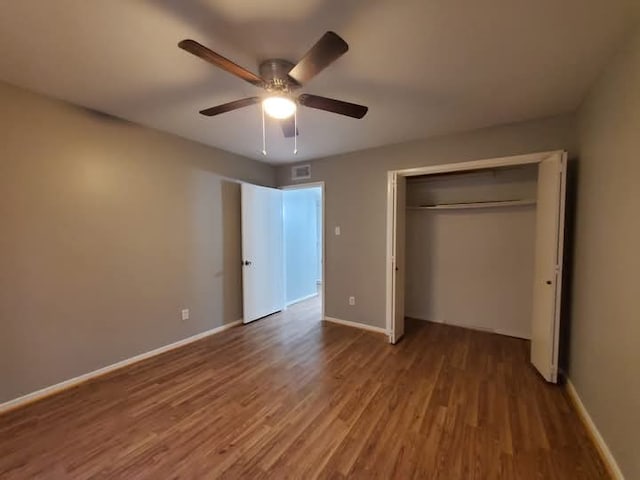 unfurnished bedroom with hardwood / wood-style flooring, ceiling fan, and a closet