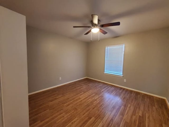 spare room featuring ceiling fan and dark wood-type flooring