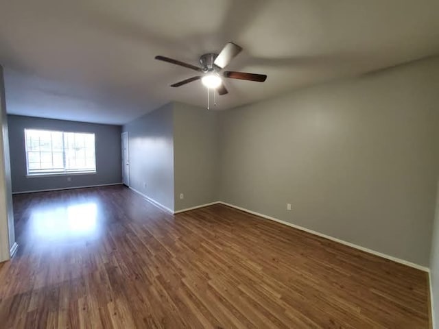 empty room with ceiling fan and dark wood-type flooring