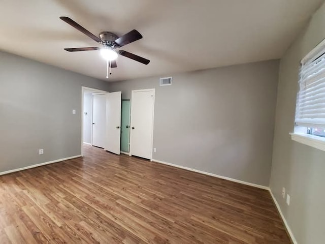 unfurnished bedroom with ceiling fan and wood-type flooring