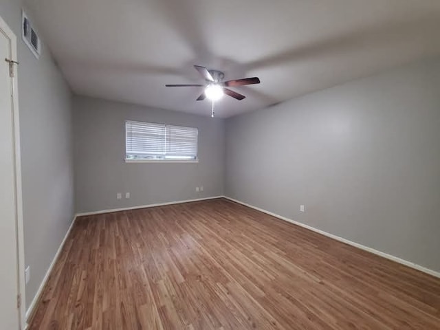 spare room with hardwood / wood-style floors and ceiling fan