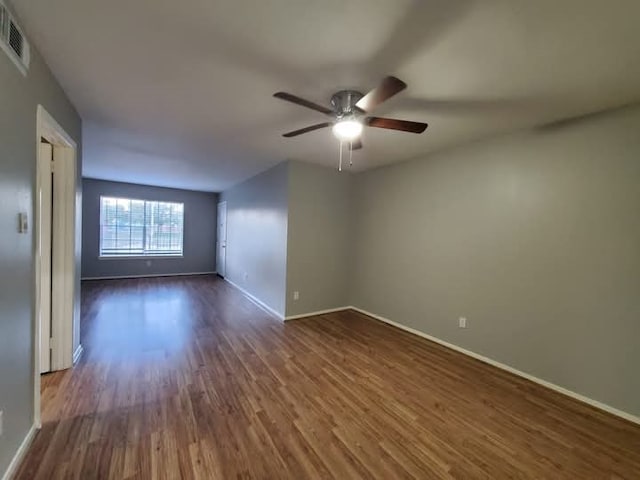 empty room with dark hardwood / wood-style floors and ceiling fan