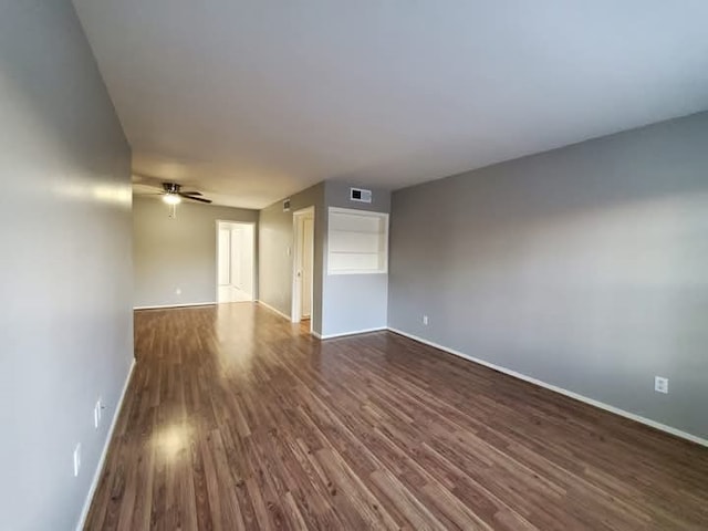 spare room with ceiling fan and dark wood-type flooring