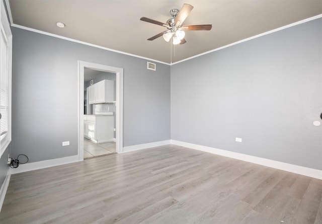 empty room featuring light wood-type flooring, ceiling fan, and ornamental molding