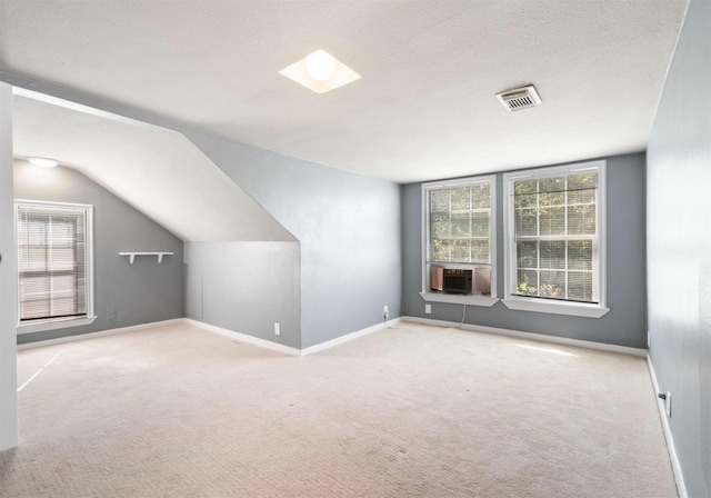 bonus room with a textured ceiling, cooling unit, lofted ceiling, and light carpet