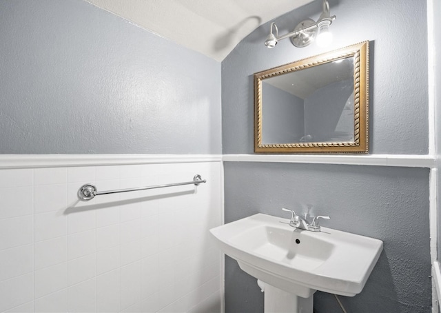 bathroom with lofted ceiling and sink