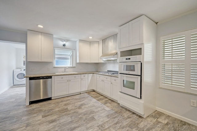 kitchen with washer / dryer, stainless steel appliances, and white cabinetry