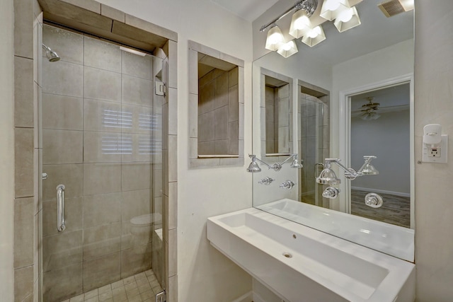 bathroom featuring ceiling fan and a shower with door