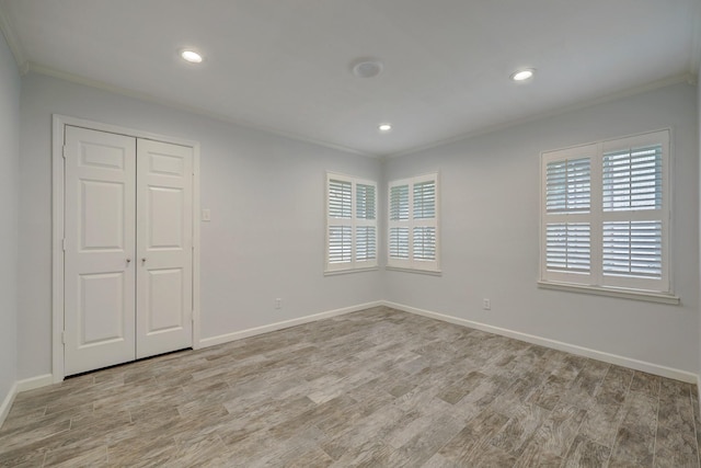 unfurnished bedroom featuring light hardwood / wood-style floors, a closet, and crown molding