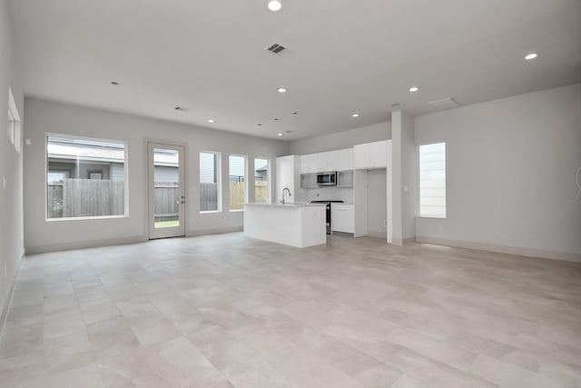 unfurnished living room featuring sink