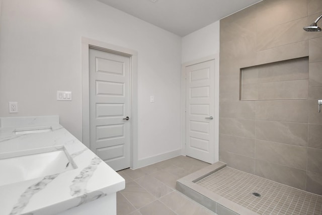 bathroom featuring vanity, tile patterned flooring, and a tile shower