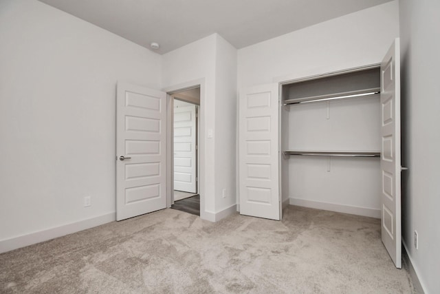 unfurnished bedroom featuring a closet and light carpet