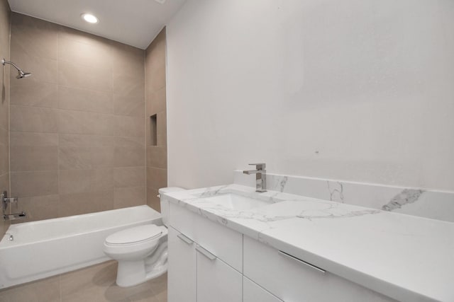 full bathroom featuring tile patterned flooring, vanity, tiled shower / bath, and toilet