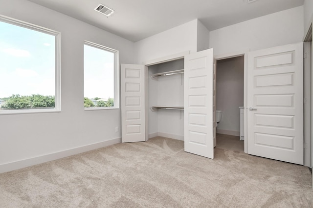 unfurnished bedroom featuring light colored carpet and a closet