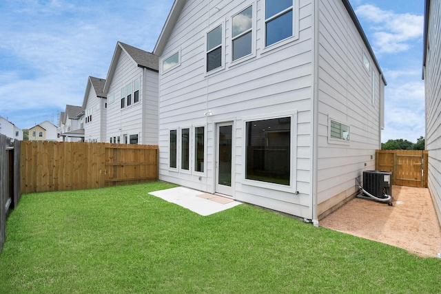 back of property featuring a lawn, central air condition unit, and a patio area