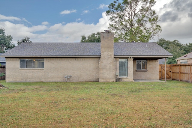 rear view of property featuring a yard