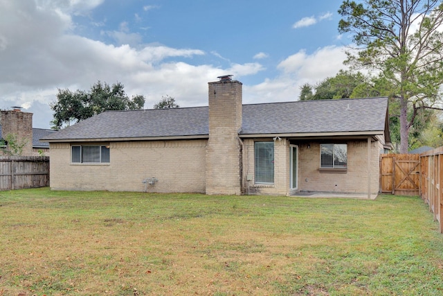 rear view of property featuring a lawn