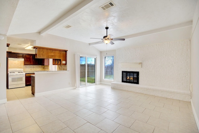 unfurnished living room featuring vaulted ceiling with beams, ceiling fan, light tile patterned flooring, and a brick fireplace