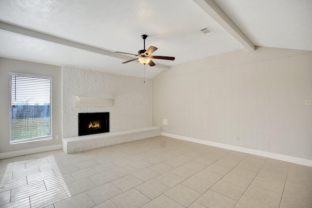 unfurnished living room featuring vaulted ceiling with beams, light tile patterned flooring, a fireplace, and ceiling fan