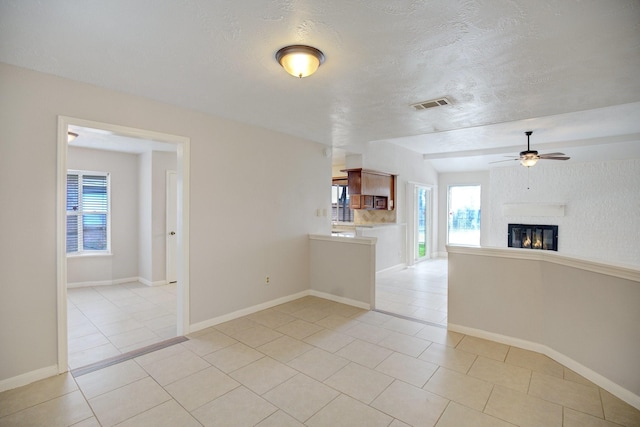 interior space with a textured ceiling and ceiling fan