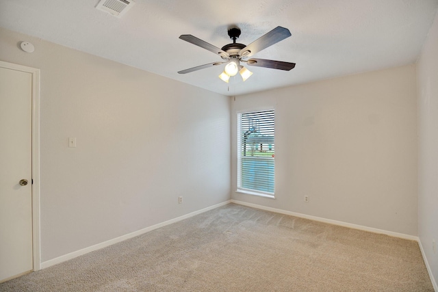 carpeted spare room featuring ceiling fan