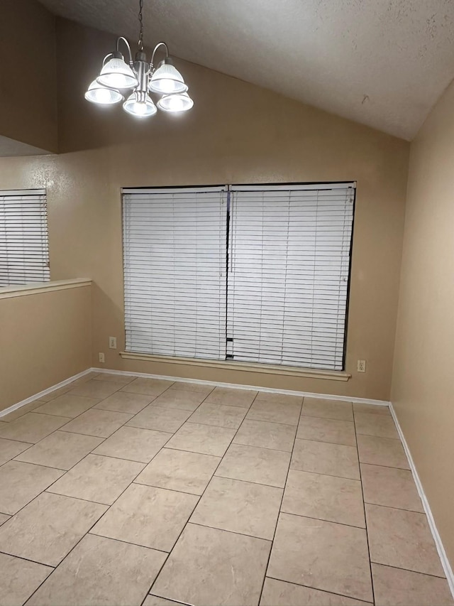 interior space featuring a notable chandelier, light tile patterned flooring, lofted ceiling, and a textured ceiling