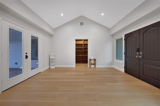 foyer featuring french doors, light hardwood / wood-style floors, and vaulted ceiling