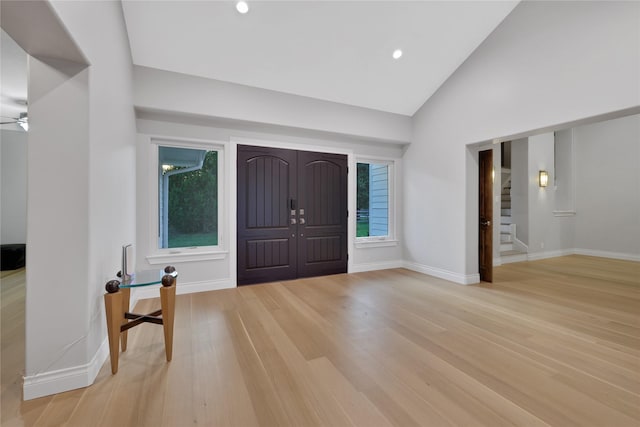 foyer entrance with ceiling fan, light hardwood / wood-style floors, and lofted ceiling