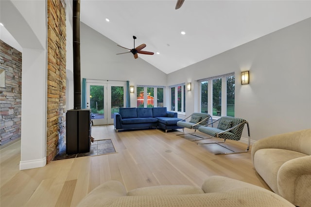 living room featuring ceiling fan, a healthy amount of sunlight, light hardwood / wood-style floors, and high vaulted ceiling