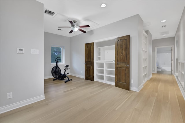 hallway featuring built in shelves and light wood-type flooring