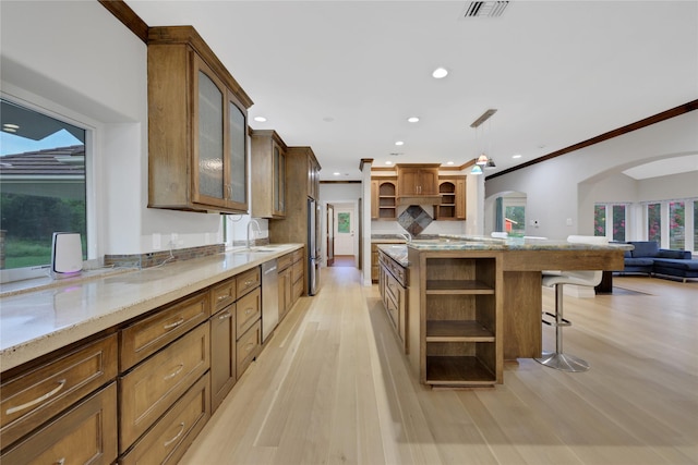 kitchen with ornamental molding, a breakfast bar, dishwasher, light hardwood / wood-style floors, and hanging light fixtures