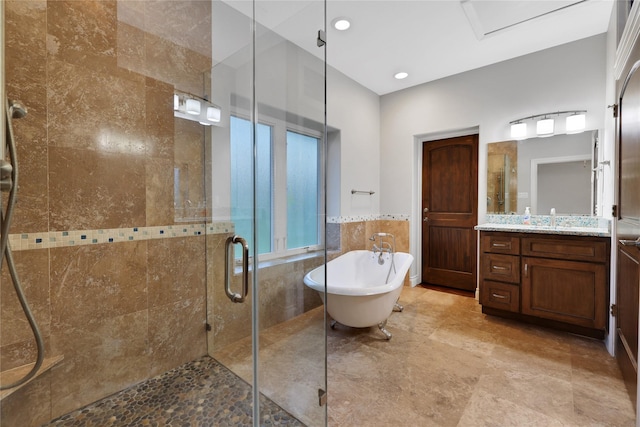 bathroom with vanity, shower with separate bathtub, and tile walls