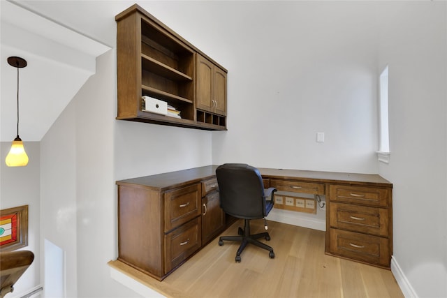 office space with built in desk and light hardwood / wood-style floors