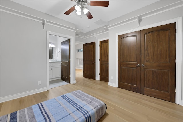 bedroom with ensuite bath, ceiling fan, and light hardwood / wood-style floors