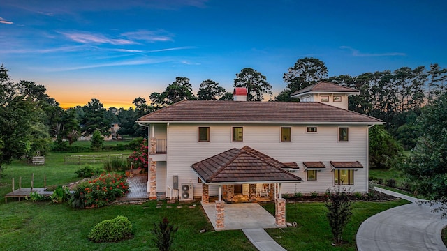 view of front of house with a lawn and a balcony