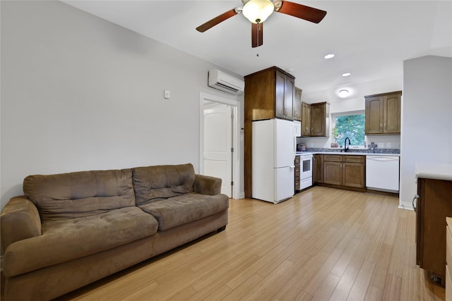 living room with ceiling fan, light hardwood / wood-style floors, an AC wall unit, and sink