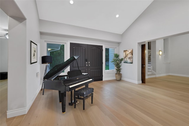 miscellaneous room featuring high vaulted ceiling, light hardwood / wood-style flooring, and ceiling fan