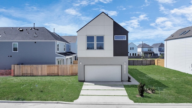 view of front facade featuring a front yard, concrete driveway, fence, and a residential view